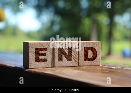 L'inscription se termine sur des cubes en bois sur une table à l'extérieur dans la nature. Concept d'entreprise Banque D'Images