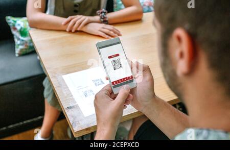 Code QR du menu restaurant scanné par un homme Banque D'Images