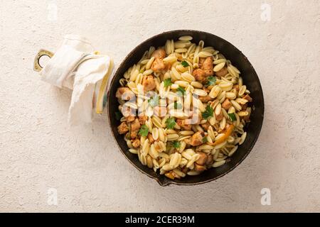 Pâtes gnocchi au poulet, herbes dans une casserole. Cuisine italienne. Coriandre, persil, oignons frits, vue de dessus Banque D'Images