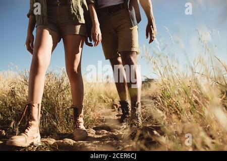 Gros plan sur des jambes de deux personnes marchant sur un sentier de randonnée. Couple marchant sur un sentier accidenté portant des chaussures de randonnée. Banque D'Images