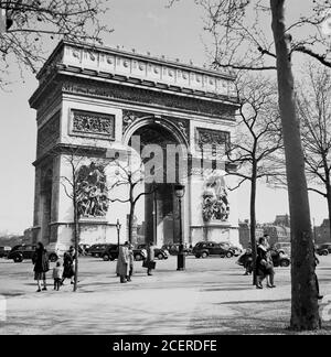 Années 1950, tableau historique par J Allan espèces montrant des véhicules de la journée au célèbre monument, Arc de Triomphe, situé près de l'Etoile et l'Avenue des Champs-Élysées. L'impressionnant monument a été construit pour célébrer les victoires militaires de Napoléon et l'armée française et a été achevé en 1836. Banque D'Images