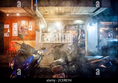 Un petit restaurant thaïlandais familial ouvert pour les affaires lors d'une pluie abondante dans une rue latérale sur Sukhumvit Rd. Bangkok, Thaïlande. Banque D'Images