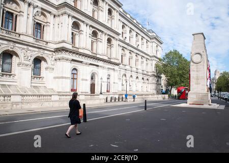 Un homme passe devant le Cenotaph, et le Foreign and Commonwealth Office sur Whitehall, à Westminster, Londres. Banque D'Images