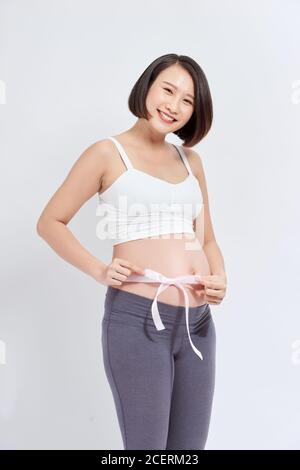 ventre enceinte avec ruban rose - maternité Banque D'Images