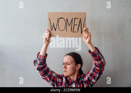Femme militante avec une affiche près d'un mur en béton dans la rue. Pour les droits des femmes Banque D'Images