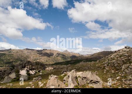 Paysage de montagne vert et rocailleux sous un ciel bleu avec nuages blancs et nuances de nuages sur la vue Banque D'Images