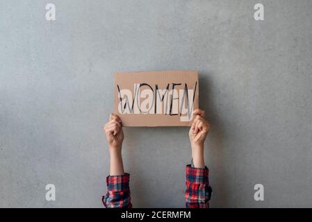 Femme activiste mains avec une affiche près du mur de béton dans la rue. Pour les droits des femmes Banque D'Images