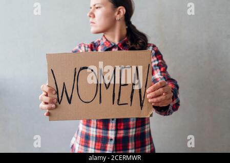 Femme militante avec une affiche près d'un mur en béton dans la rue. Pour les droits des femmes Banque D'Images
