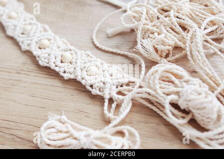 Ceinture macrame faite à la main en cours de travail. Fils de coton naturel et perles de bois. Décoration élégante pour la robe pour femme. Tresse en macrame et coton TH Banque D'Images