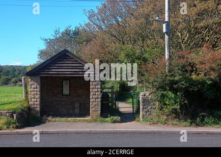 L'abri de bus marquant le chemin qui emmène les marcheurs côtiers à travers les pâturages et au-dessus de la rivière Ewenny jusqu'à l'église de Candleston sur Merthyr Mawr. Banque D'Images