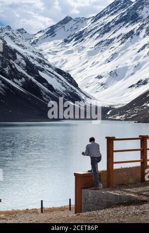 Homme regardant le lac Laguna del Inca entouré par Montagnes au Chili Banque D'Images