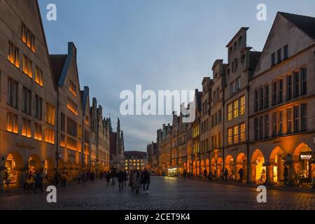 Muenster, Prinzipalmarkt avec ses vieilles maisons à pignons au crépuscule, heure bleue, les gens se baladent sur la célèbre rue commerçante mondiale, ancienne route pavée, Banque D'Images