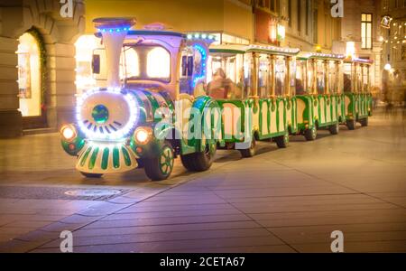 Le moteur des enfants de Noël dans la rue le soir Banque D'Images