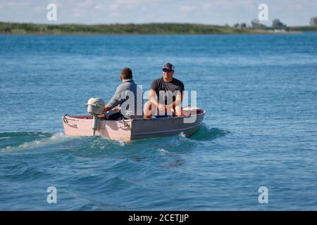 Deux hommes dans un petit bateau hors-bord sur un lac. Banque D'Images