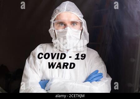 Homme en costume de protection et en masque médical de protection montrant un geste d'arrêt. Portrait d'épidémiologiste. Arrêter le coronavirus ou le covid-19 et la pandémie Banque D'Images