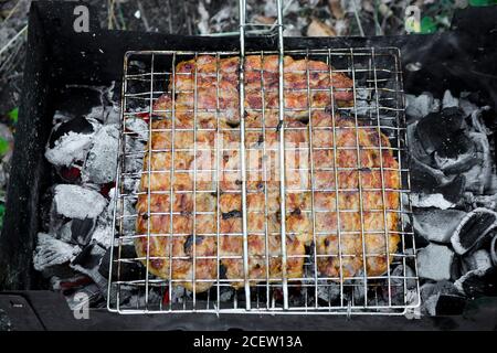 Barbecue le porc est grillé sur le grill au charbon de bois. Concept de cuisine extérieure. Banque D'Images