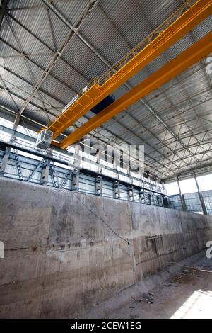 Intérieur en béton gris avec pont roulant jaune intérieur nouveau bâtiment industriel. Atelier d'usine d'engrais phosphoriques. Banque D'Images