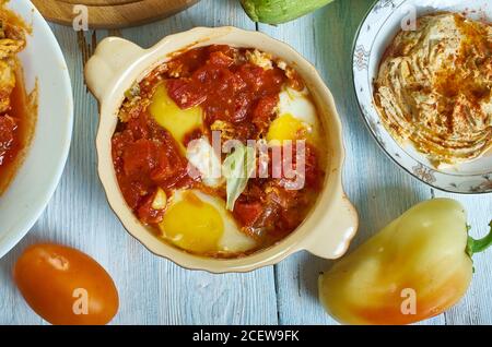Shakshouka, plat d'oeufs pochés dans une sauce de tomates, huile d'olive, poivrons, oignon et ail, cuisine israélienne, assortiment traditionnel méditerranéen d Banque D'Images