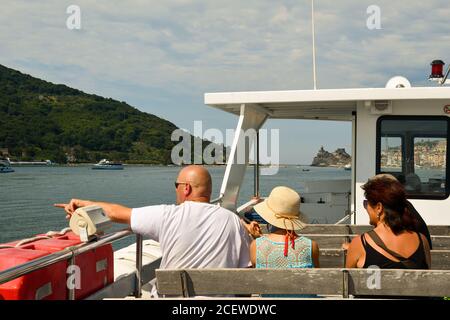 Une famille de derrière assise sur un ferry pour Porto Venere avec l'île de Palmaria en arrière-plan, le golfe de Poètes, la Spezia, Ligurie, Italie Banque D'Images