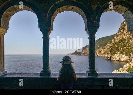 Petite fille de derrière en admirant la vue depuis une arcade de l'église Saint-Pierre dans le village de pêcheurs de Porto Venere, la Spezia, Ligurie, Italie Banque D'Images