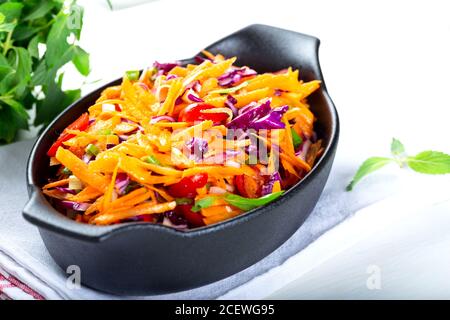 Salade de chou rouge et de carottes avec oignon vert et tomates cerises. Coleslaw pour l'automne ou l'hiver. Banque D'Images