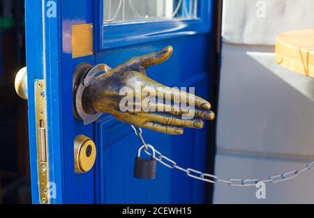 Poignée de porte élégante en métal doré en forme de main avec menottes Banque D'Images