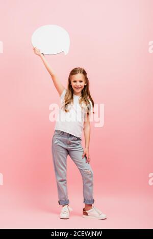 vue sur toute la longueur d'une fille avec un t-shirt blanc et un jean tenir la bulle de pensée au-dessus de la tête sur rose Banque D'Images