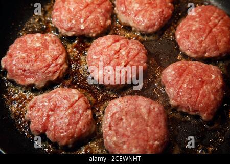 Quelqu'un cuisant des steaks de viande hachés. Photo Jeppe Gustafsson Banque D'Images