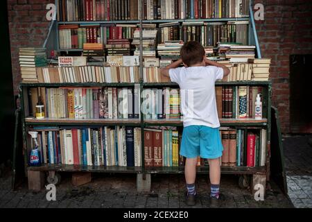 Belgrade, Serbie, 31 août 2020 : un garçon immergé dans des livres à la librairie de rue de Zemun Banque D'Images