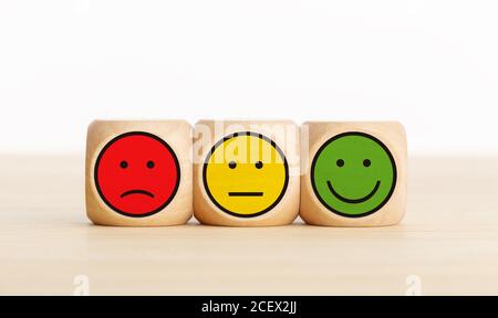 Commentaires du service aux utilisateurs, évaluation de l'avis des clients, sondage, concept d'enquête de satisfaction. Blocs de bois avec expressions du visage Banque D'Images