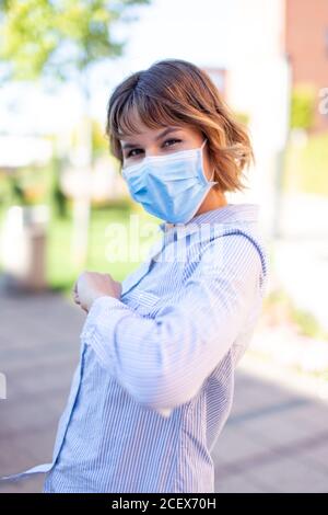 Jeune femme en accueil masque avec coude à l'extérieur dans le parc pendant une pandémie Banque D'Images