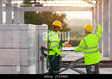 Les ingénieurs et les travailleurs asiatiques se sont consultés ensemble pour la planification et le développement de la construction, le concept de travail d'équipe de construction. Banque D'Images