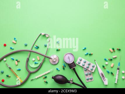 Tensiomètre, équipement médical et médecine sur fond vert pastel, vue rapprochée. Traitement de l'hypertension, concept de médicament Banque D'Images