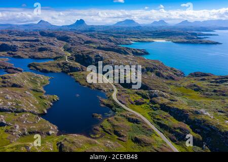 Vue aérienne des montagnes et route à voie unique partie de la côte nord 500 dans la région d'Assynt Coigach dans les Highlands écossais, Écosse, Royaume-Uni Banque D'Images