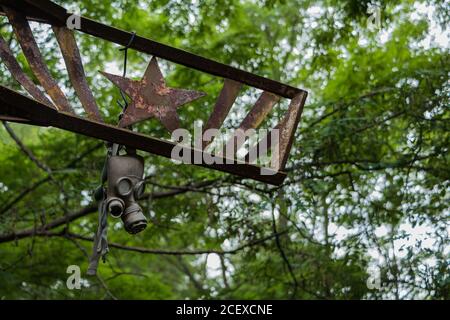 Une photo d'un masque à gaz hanging off un symbole soviétique dans la région de Pripiat. Banque D'Images