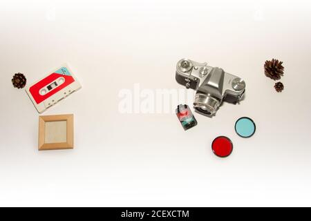 Ancien appareil photo rétro, objectif couleur, cassette ruban plat, fond blanc vierge. Vue de dessus affiche blanche espace de maquette pour le texte Banque D'Images