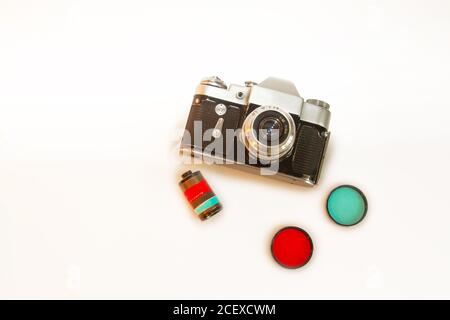 Ancien appareil photo rétro, lentille couleur plat, fond blanc. Vue de dessus intérieur maison maquette d'affiche blanche, espace pour le texte Banque D'Images