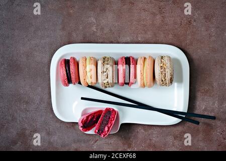 Gâteaux de macarons assortis français sur un plat rectangulaire. Petits gâteaux français colorés. Vue de dessus. Banque D'Images