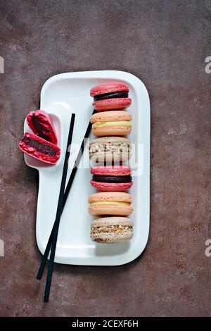 Gâteaux de macarons assortis français sur un plat rectangulaire. Petits gâteaux français colorés. Vue de dessus. Banque D'Images