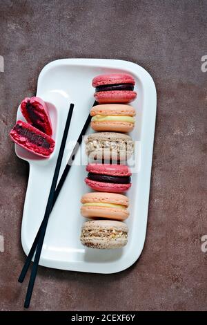 Gâteaux de macarons assortis français sur un plat rectangulaire. Petits gâteaux français colorés. Vue de dessus. Banque D'Images