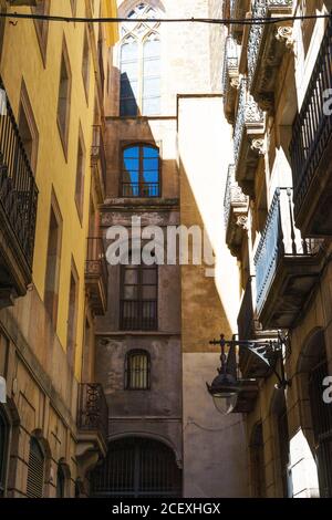 Angle bas de rue étroite avec les anciens bâtiments résidentiels éclairés Par la lumière du soleil à Barcelone Banque D'Images