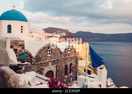 Santorini île Oia coucher de soleil paysage. Maisons blanches traditionnelles et architecture d'église avec vue sur la mer. Voyage en Grèce. Banque D'Images