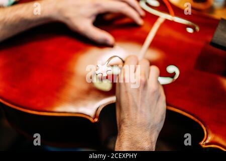 Rognez l'artisan anonyme qui définit le poste sonore tout en construisant un instrument à cordes en atelier Banque D'Images