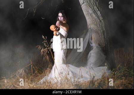 Scène d'horreur d'une femme possédée tenant une poupée. Photo de haute qualité Banque D'Images