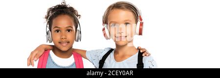 prise de vue panoramique d'écoliers multiculturels écoutant de la musique dans un casque sans fil isolé sur blanc Banque D'Images