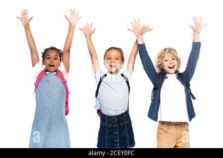 écolières et garçons multiculturels excités, les mains levées isolées blanc Banque D'Images