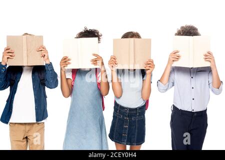 des écolières et des écoliers multiculturels couvrant des visages avec des livres isolés blanc Banque D'Images