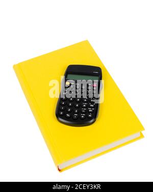 Photo verticale d'un livre jaune vif avec une calculatrice sur fond blanc. Banque D'Images