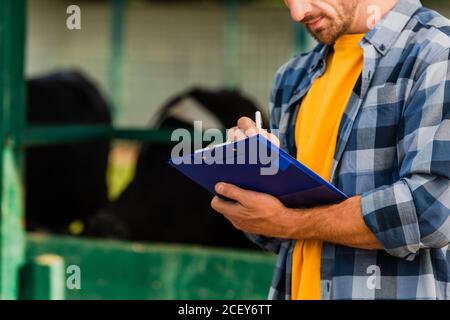 vue rognée de l'agriculteur dans une chemise à carreaux sur le presse-papiers Banque D'Images