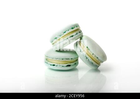 Macarons colorés sur fond blanc réfléchissant. Banque D'Images